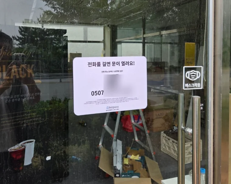 전화 출입 안내문을 붙인 매장 출입문